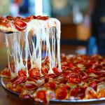 A Mountain Mike's slice oozing cheese as its pulled from a pie.