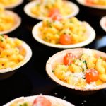 At the 2025 U.S. Open, Coqodaq returns with chicken nuggets and caviar flatbreads, while Aces by Morimoto and Onwuachi showcase sushi and Laotian wagyu skewers courtside.