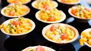 At the 2025 U.S. Open, Coqodaq returns with chicken nuggets and caviar flatbreads, while Aces by Morimoto and Onwuachi showcase sushi and Laotian wagyu skewers courtside.