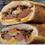 Two halves of Snarf's Sandwiches' hot dog sandwich stacked on top of each other