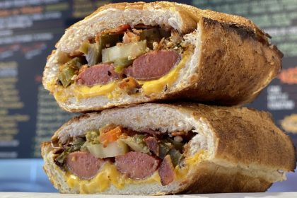 Two halves of Snarf's Sandwiches' hot dog sandwich stacked on top of each other