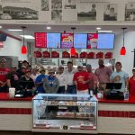 ​This image shows employees posing for a picture at the Rosharon location of Shipley Do-Nuts.