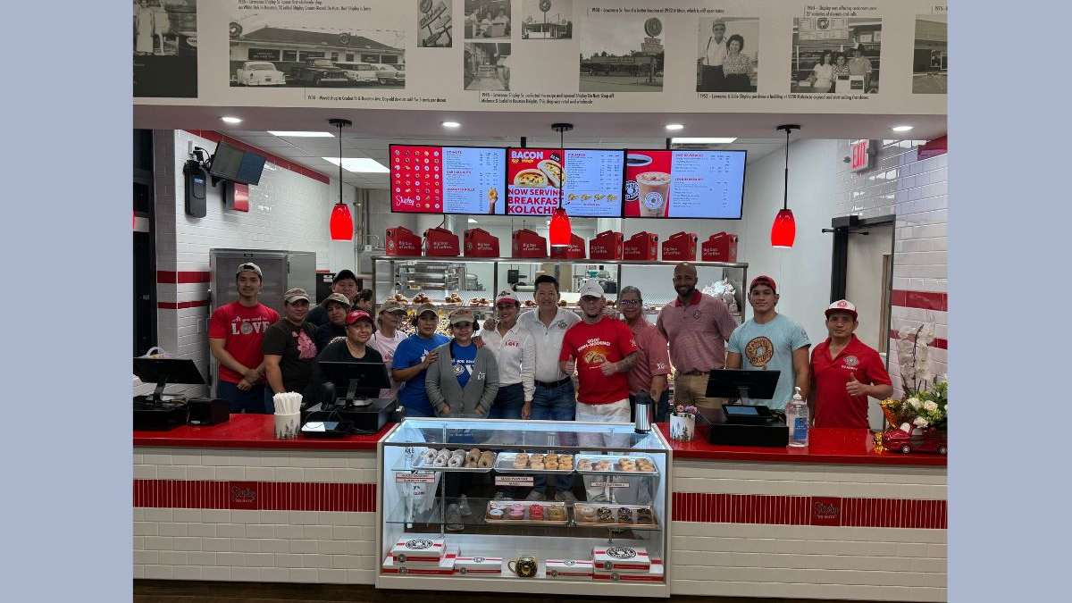 ​This image shows employees posing for a picture at the Rosharon location of Shipley Do-Nuts.