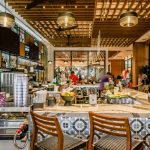 Known for tropical cocktails, seafood-forward bites, and "toes in the sand" vibes